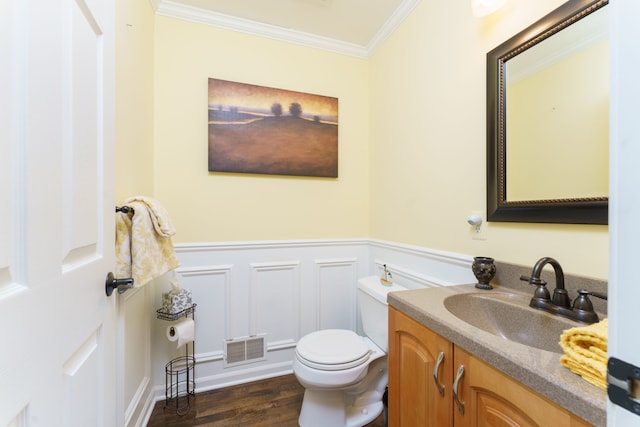 bathroom with crown molding, vanity, wood-type flooring, and toilet