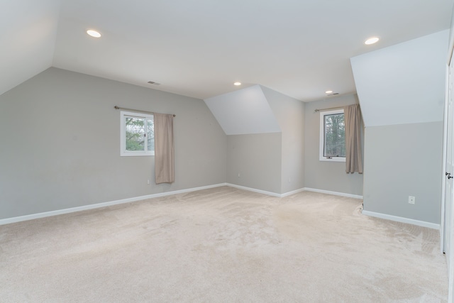 additional living space with light colored carpet, lofted ceiling, and a wealth of natural light