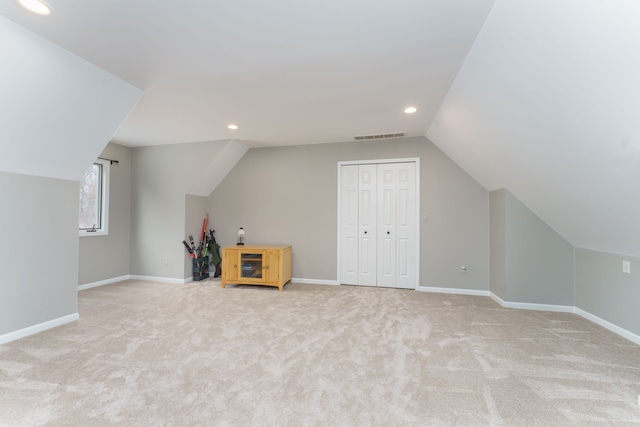 bonus room with light colored carpet and lofted ceiling