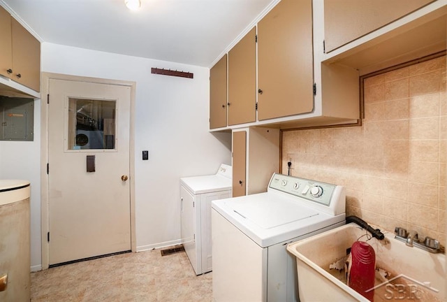 laundry room featuring cabinet space, washing machine and dryer, a sink, electric panel, and baseboards