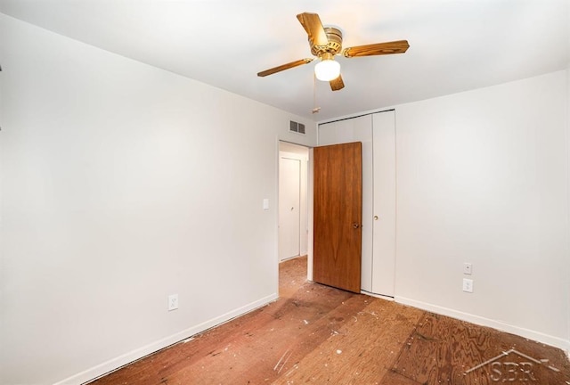 empty room with baseboards, visible vents, and a ceiling fan