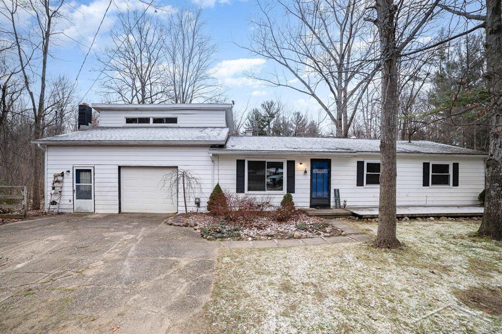 view of front of home with driveway, a chimney, and an attached garage