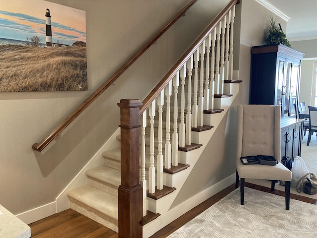 stairs featuring crown molding and hardwood / wood-style flooring