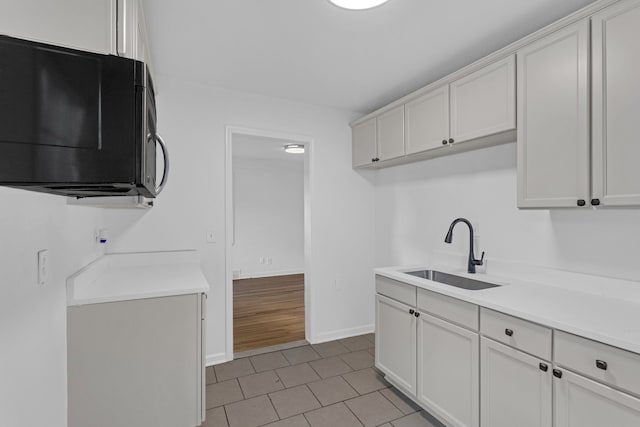 kitchen with white cabinets, light tile patterned flooring, and sink