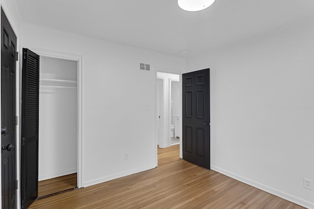 unfurnished bedroom featuring a closet and light hardwood / wood-style flooring