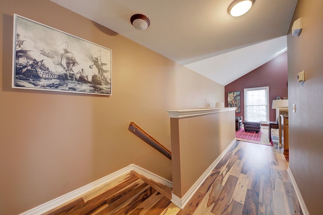 hall with light hardwood / wood-style floors and vaulted ceiling