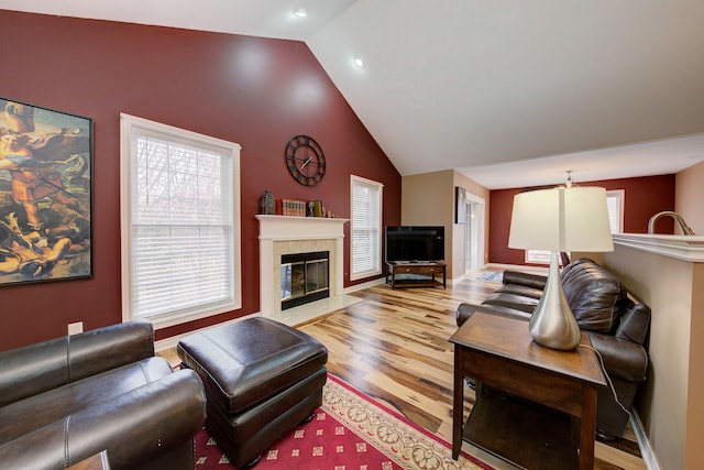 living room with a fireplace, vaulted ceiling, and hardwood / wood-style flooring