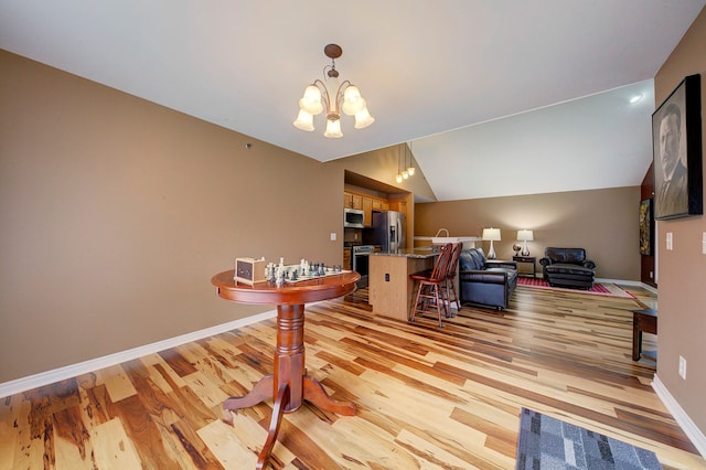 home office with light wood-type flooring, an inviting chandelier, and lofted ceiling