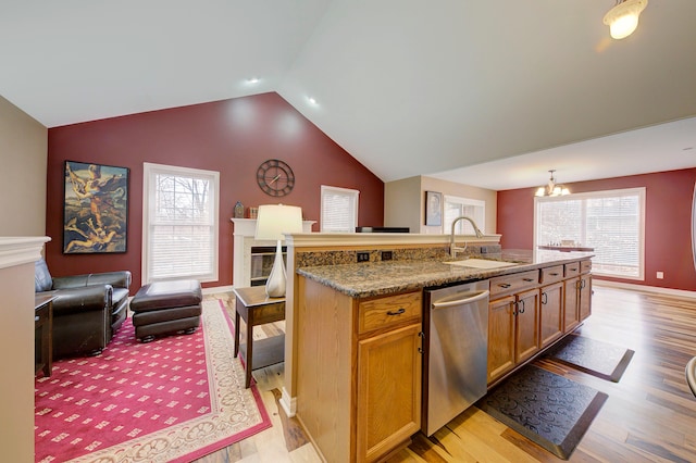 kitchen with light hardwood / wood-style flooring, stainless steel dishwasher, a kitchen island with sink, and sink