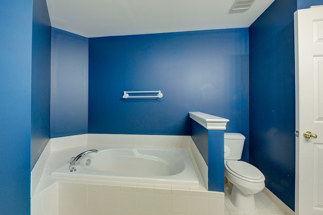 bathroom with tile patterned floors, a relaxing tiled tub, and toilet