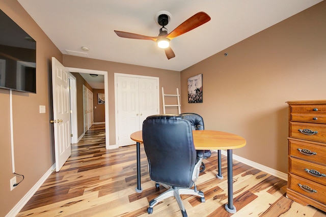 home office with ceiling fan and light hardwood / wood-style flooring