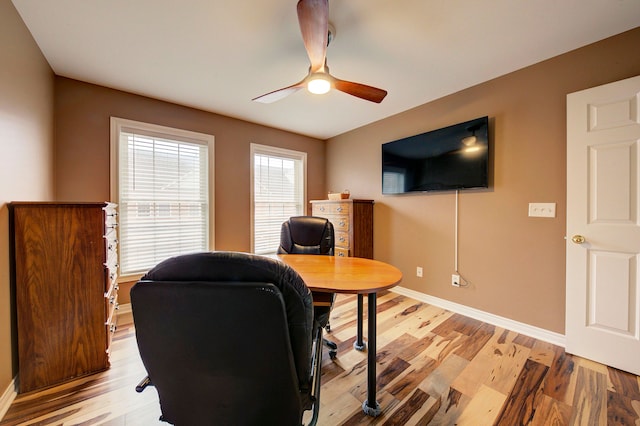 home office with light hardwood / wood-style flooring and ceiling fan