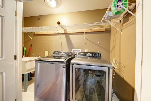 clothes washing area with light tile patterned floors and washing machine and clothes dryer