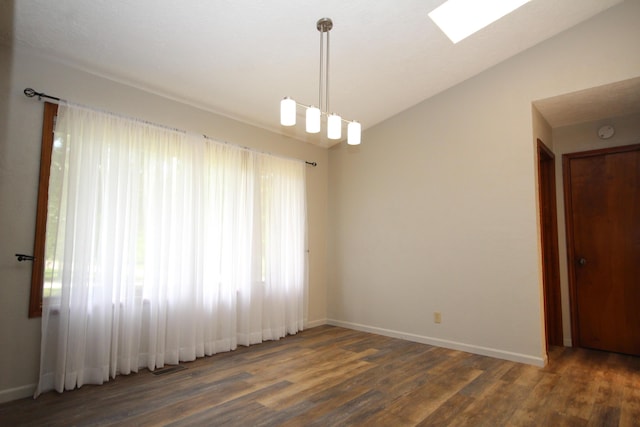 empty room featuring vaulted ceiling with skylight and dark wood-type flooring