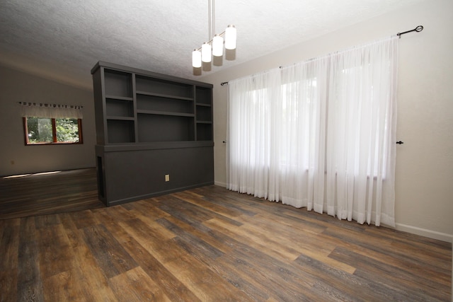 unfurnished room featuring a textured ceiling, lofted ceiling, and dark wood-type flooring