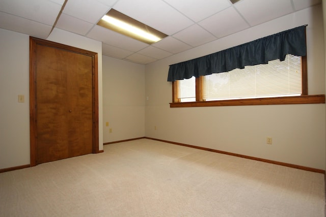 empty room featuring carpet flooring and a paneled ceiling