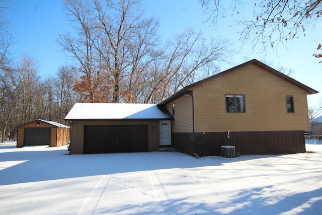 view of snow covered exterior featuring an outdoor structure and a garage