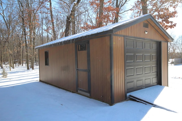 snow covered structure with a garage