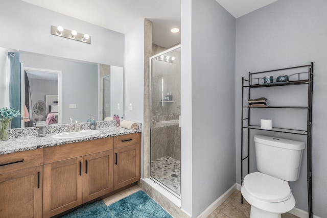 bathroom featuring toilet, vanity, tile patterned floors, and a shower with shower door