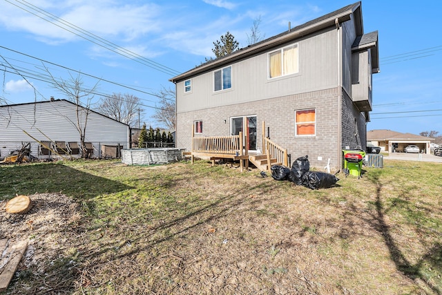 rear view of house with a yard, a deck, and central AC unit