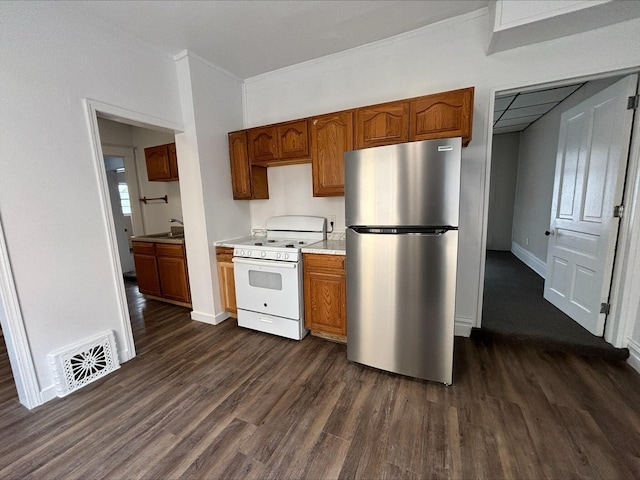 kitchen featuring ornamental molding, white gas range oven, stainless steel refrigerator, and dark wood-type flooring