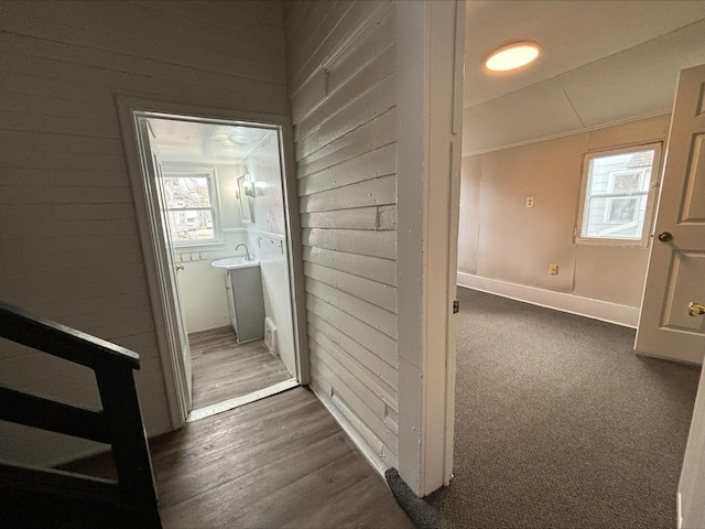 corridor with dark colored carpet and sink