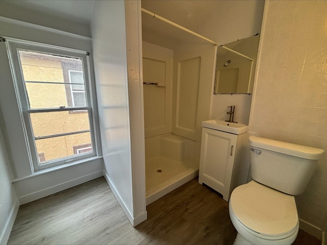 bathroom with hardwood / wood-style floors, toilet, walk in shower, and a wealth of natural light