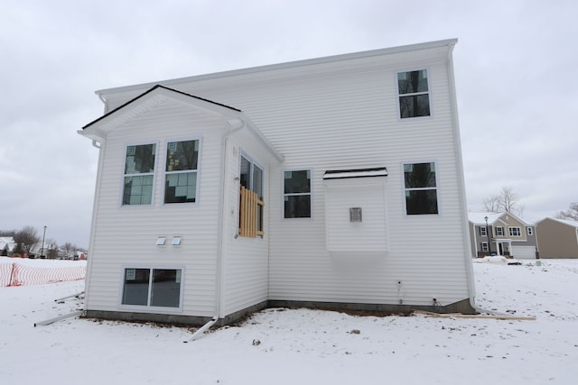 view of snow covered back of property