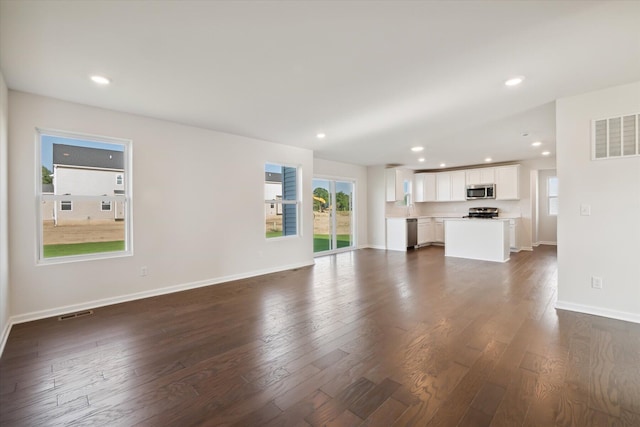 unfurnished living room with dark wood-type flooring