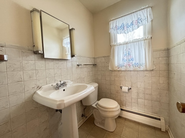 bathroom with tile patterned flooring, tile walls, toilet, and baseboard heating