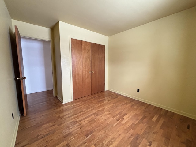 unfurnished bedroom featuring hardwood / wood-style floors and a closet