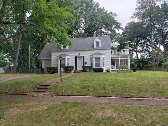 cape cod-style house with a front yard, a garage, and a sunroom