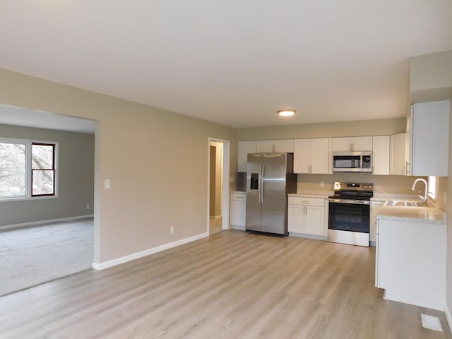 kitchen featuring white cabinets, light hardwood / wood-style floors, sink, and stainless steel appliances