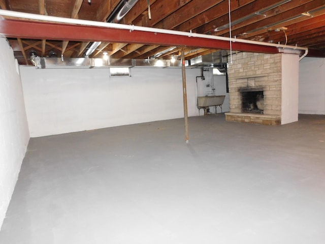 basement with sink and a fireplace