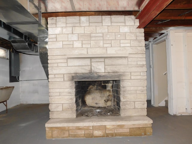 room details with concrete flooring and a stone fireplace