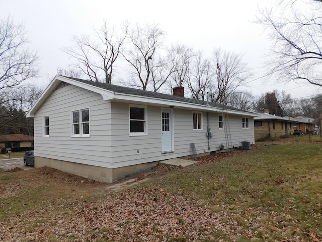 back of property featuring cooling unit and a lawn