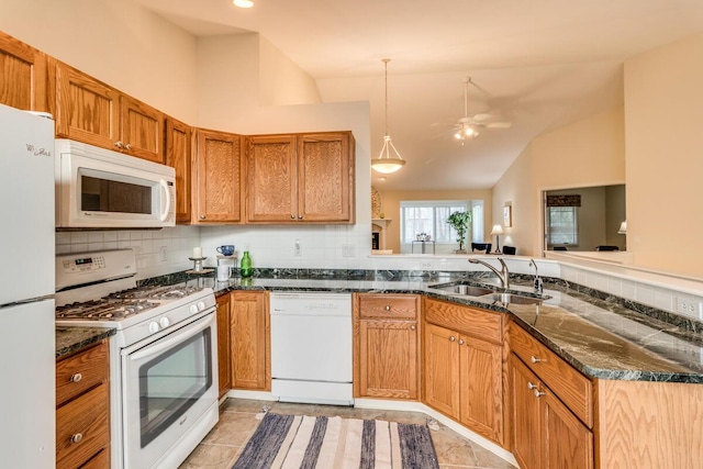 kitchen featuring white appliances, lofted ceiling, dark stone counters, a sink, and backsplash