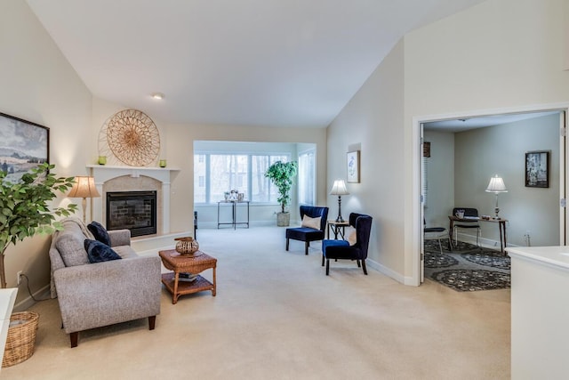 carpeted living area with a glass covered fireplace, high vaulted ceiling, and baseboards