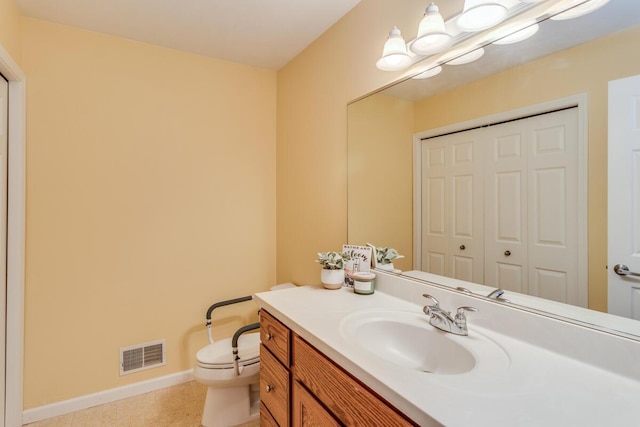 bathroom with vanity, toilet, baseboards, and visible vents