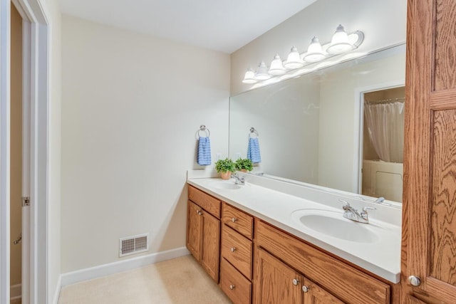 full bath with a sink, visible vents, baseboards, and double vanity