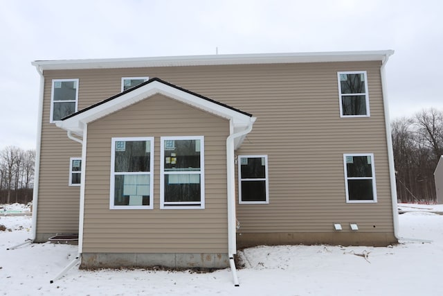 view of snow covered rear of property