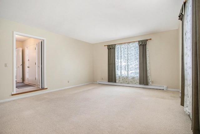 carpeted spare room featuring a baseboard heating unit