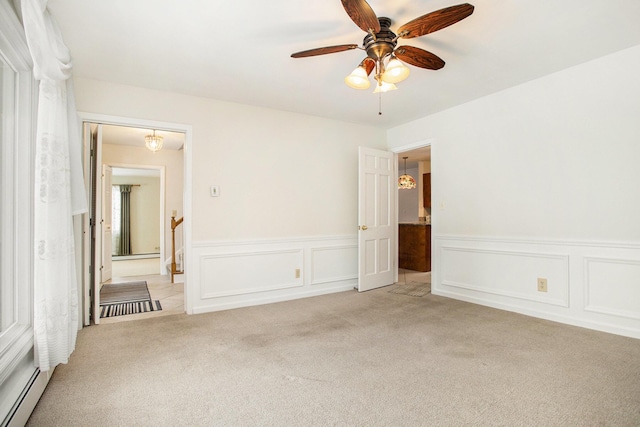 carpeted spare room with baseboard heating and ceiling fan