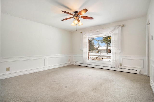 empty room with carpet flooring, ceiling fan, and a baseboard heating unit