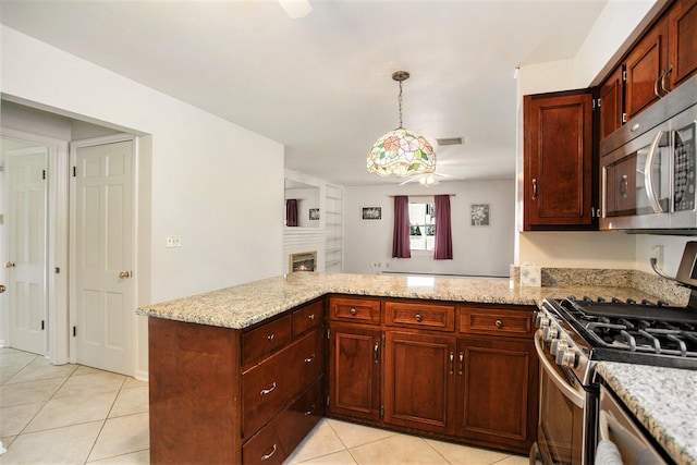 kitchen with ceiling fan, light tile patterned floors, appliances with stainless steel finishes, decorative light fixtures, and kitchen peninsula