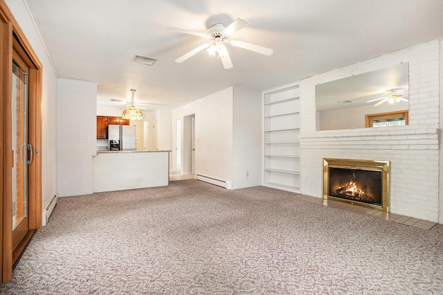 unfurnished living room featuring a brick fireplace, built in shelves, carpet floors, and a baseboard heating unit