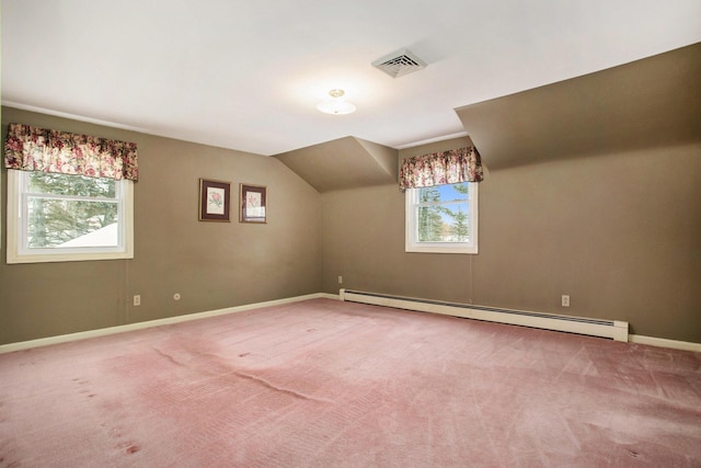 additional living space featuring carpet, baseboard heating, and a healthy amount of sunlight