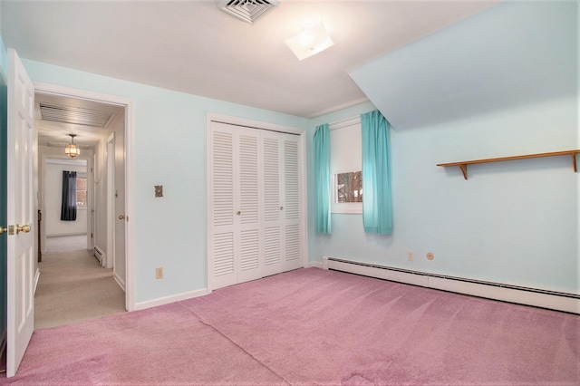 unfurnished bedroom featuring a closet, light colored carpet, and a baseboard heating unit