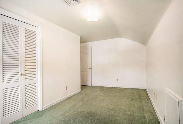 additional living space with lofted ceiling and dark colored carpet