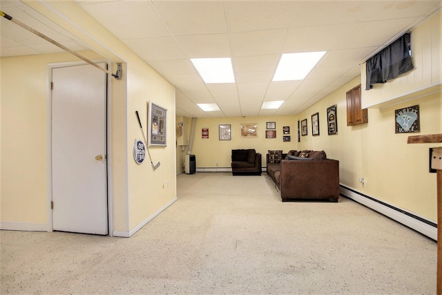 living room featuring baseboard heating and a drop ceiling